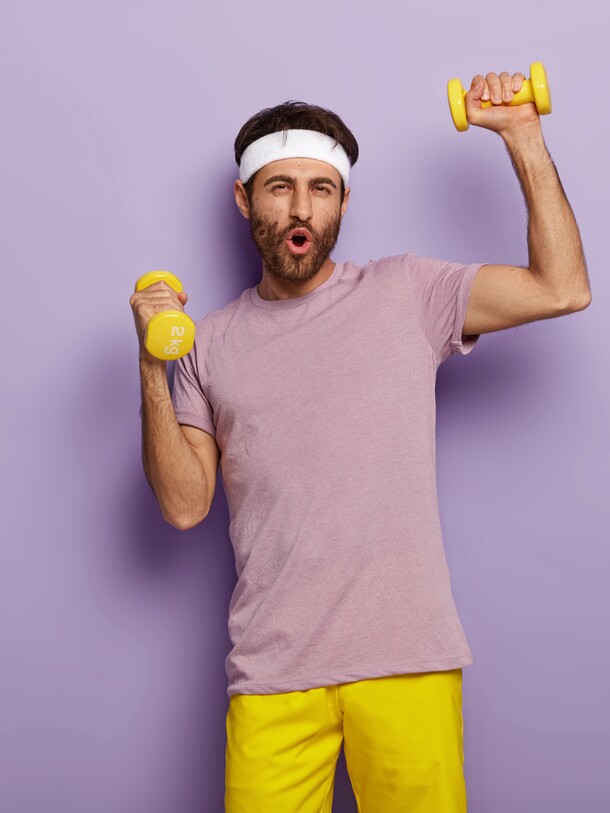 funny-man-has-fun-exercises-with-dumbbells-dressed-active-wear-motivated-healthy-lifestyle-has-regular-training-morning